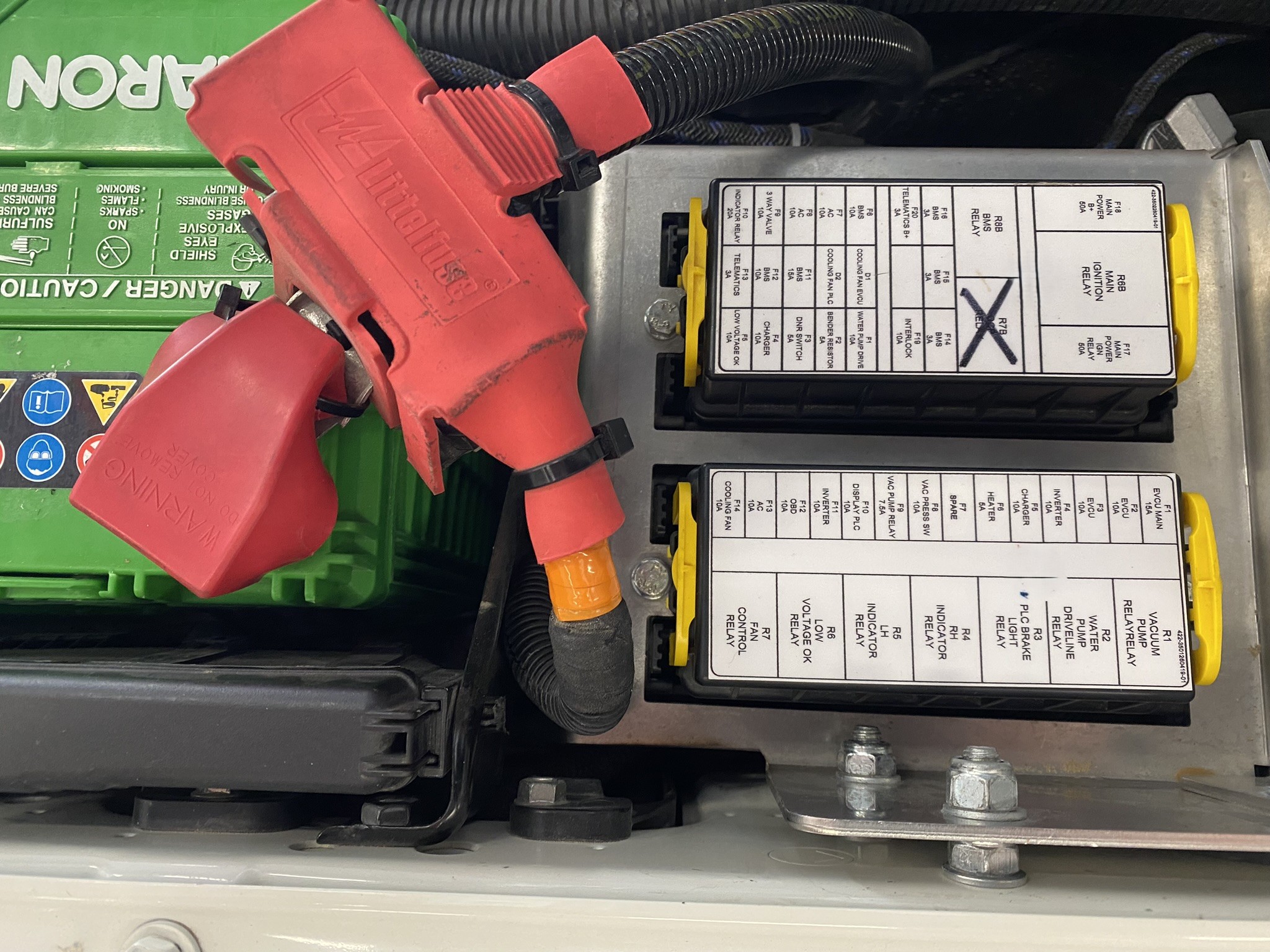 Vehicle electrical distribution panel showing 12V SLI battery, battery main fuse, labelled fuse boxes and relay panel — the kind of properly documented installation Voltforge builds and supports