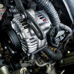 Vehicle alternator in engine bay — modern smart alternators modulate output voltage, making traditional VSR split charge systems unreliable